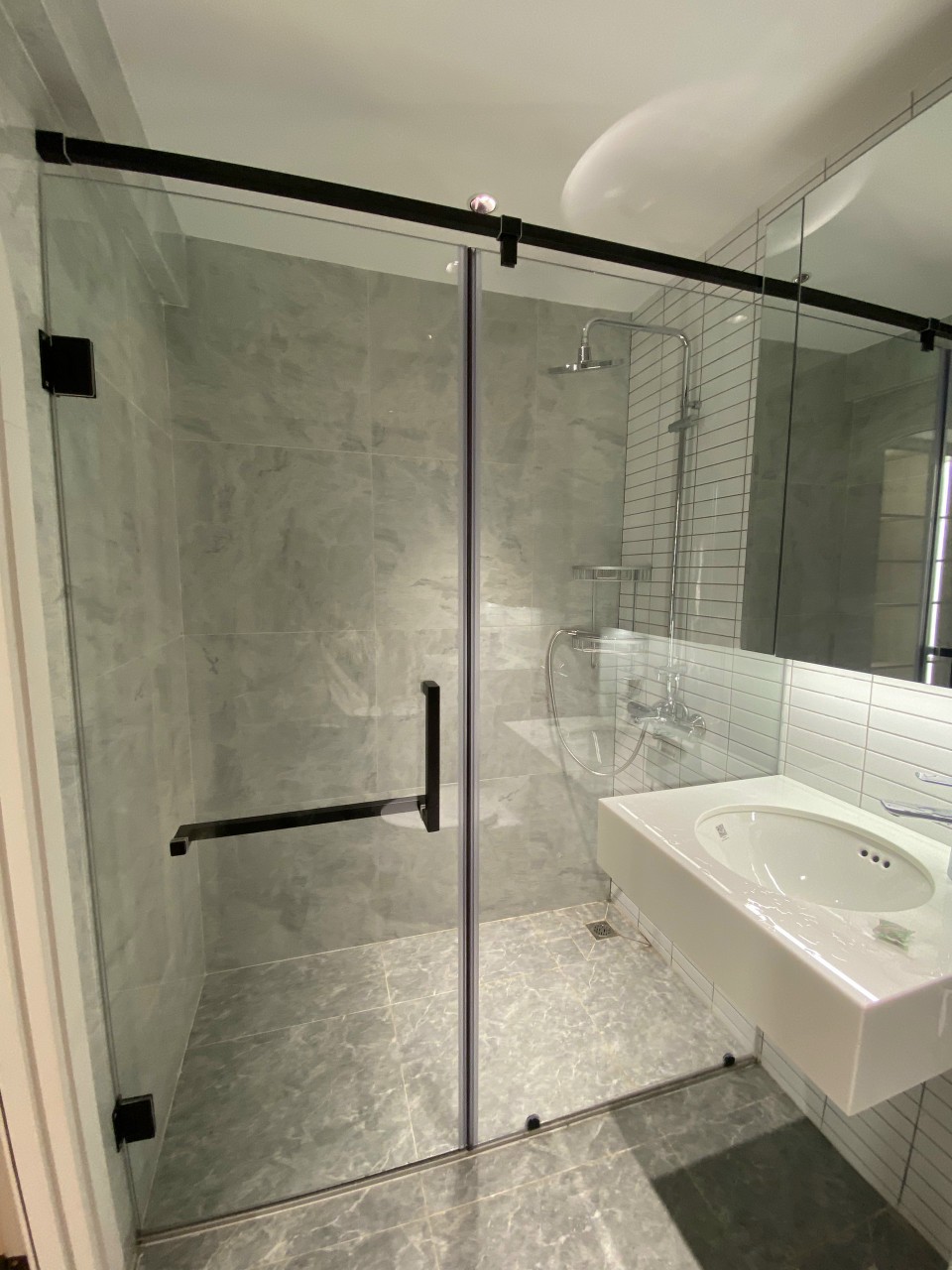 Phòng tắm kính sử dụng bản lề tường kính màu đen và bộ giằng vuông 25 màu đen