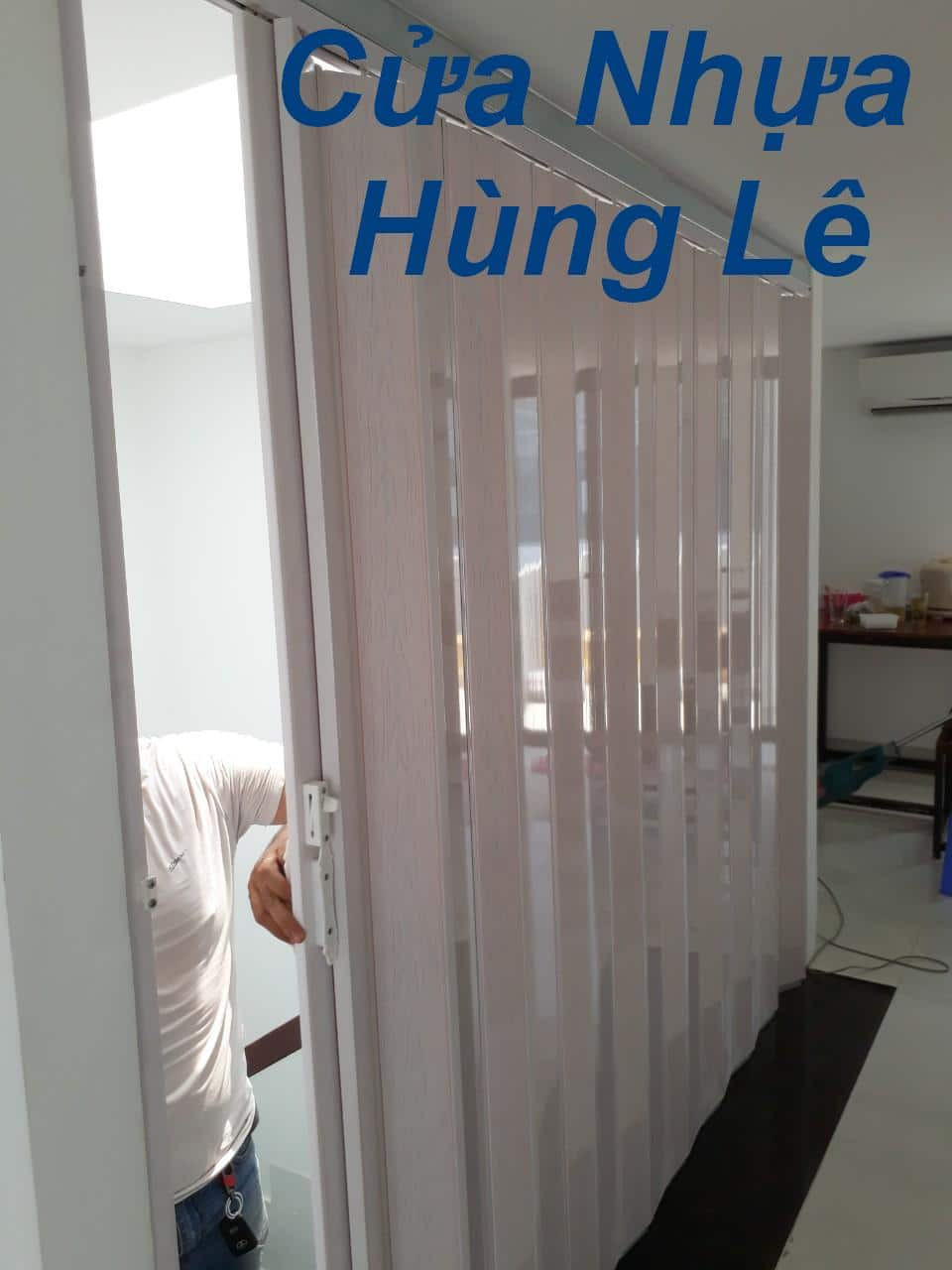 Cửa xếp nhựa màu trắng kem mở rộng, ngăn cách khu vực làm việc lớn