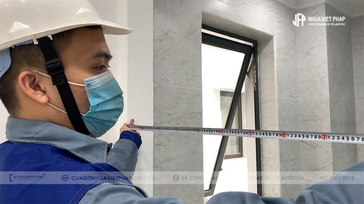 Kỹ thuật viên kiểm tra kích thước ô chờ cho việc lắp đặt cửa nhựa composite