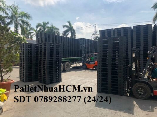 Những tấm pallet nhựa cũ màu xanh được sắp xếp gọn gàng, thể hiện hình ảnh của pallet nhựa cũ HCM với các trạng thái sử dụng khác nhau.
