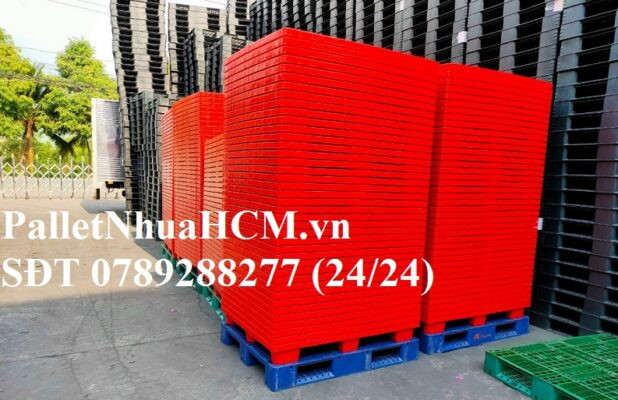 Xe nâng hàng di chuyển những tấm pallet nhựa cũ chịu tải nặng trong kho, nhấn mạnh tầm quan trọng của trọng lượng và khả năng chịu tải khi chọn mua hình ảnh của pallet nhựa cũ HCM.