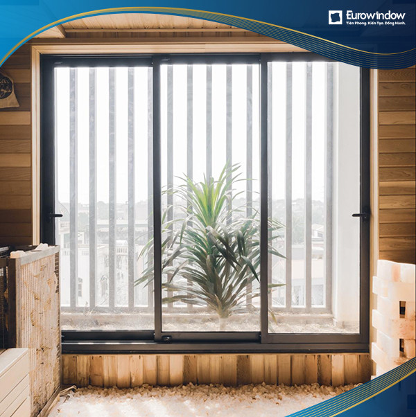 Cửa đi nhựa lõi thép Eurowindow mở trượt 3 cánh màu ghi, lắp đặt tại ban công chung cư cao cấp. Mức giá cửa uPVC Eurowindow cho thiết kế này thường phụ thuộc vào số cánh và kiểu dáng