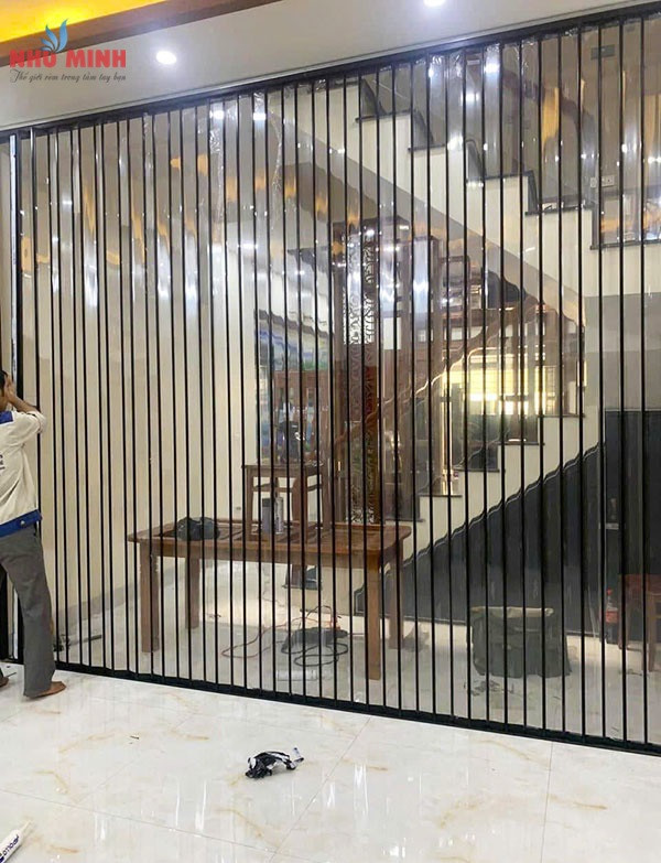 Cửa nhựa xếp lá trong suốt với khung nhôm đen lắp tại khu vực cầu thang