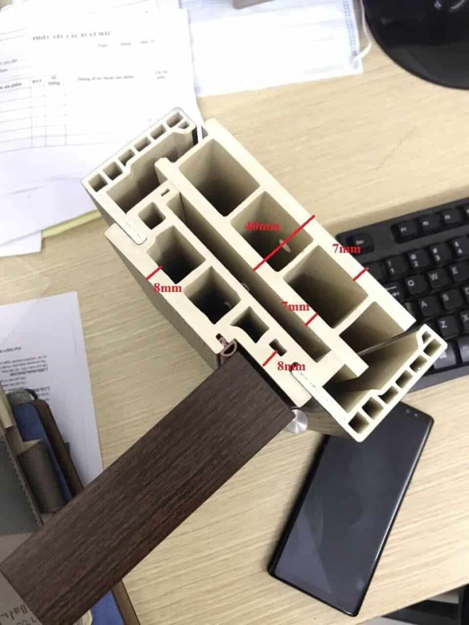 Mặt cắt cấu tạo bên trong cánh cửa nhựa composite, cho thấy lõi đặc và gioăng cao su tăng cường cách âm